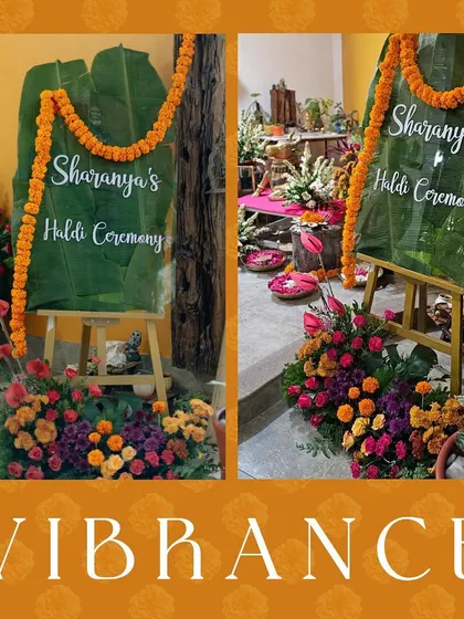 The welcome sign for the Haldi ceremony, handwritten on a large banana leaf and framed with marigold garlands, providing a natural and authentic greeting.