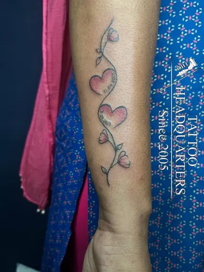 A vine with flowers and two hearts containing dates, a beautiful way to commemorate special family moments.