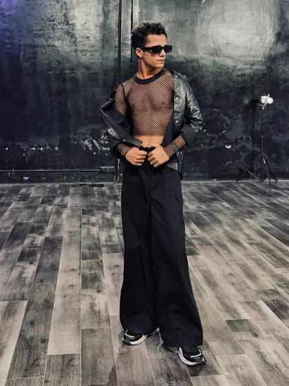 A full-body shot showcasing an edgy, all-black outfit with a leather jacket and mesh top. This look is perfect for a powerful Hip Hop or commercial performance.