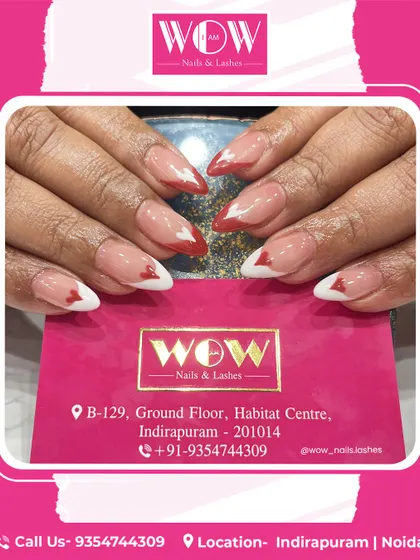 These heart-tipped extensions are a playful and romantic choice. The design features a neutral base with alternating red and white heart-shaped French tips on almond-shaped nails.