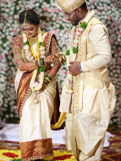A candid moment from a wedding ceremony, with the bride's dark henna stain visible as she participates in the rituals.