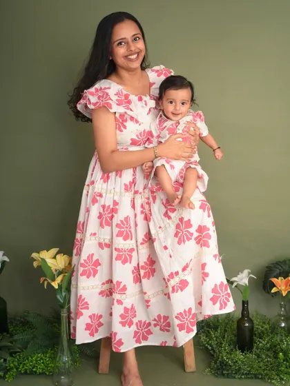 A mother and her baby, twinning in beautiful floral dresses. This portrait captures the gentle and loving bond between them.