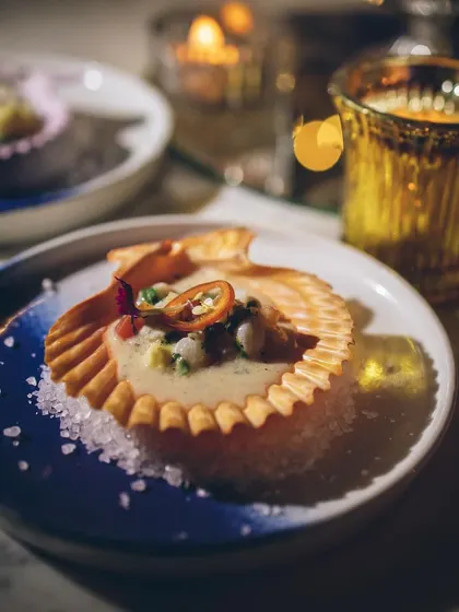 A candlelit shot of our elegant seafood appetizer served in a crispy shell.