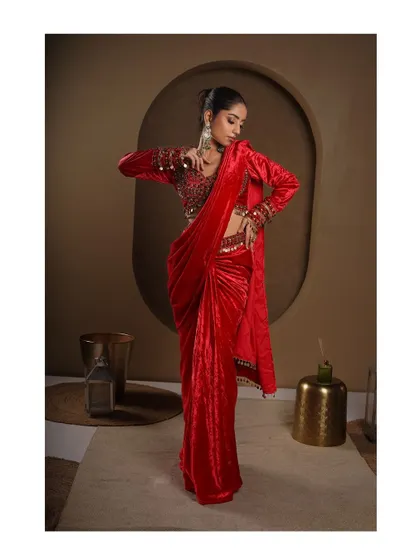 A three-quarter view of the modern red saree, showing how it drapes and moves. The pose is confident and stylish, perfect for a contemporary ethnic brand.