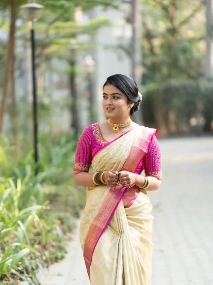 A simple and elegant look for a pre-wedding ritual. The off-white and pink saree is classic and beautiful.