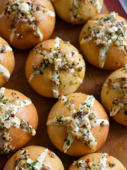 A fresh batch of Korean Cream Cheese Garlic Buns, ready to be packed. The tops are sprinkled with herbs and cheese before baking to golden perfection.