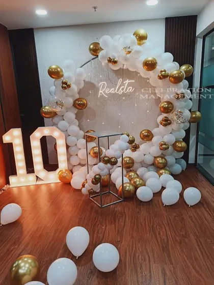 We help businesses celebrate their achievements in style. For this corporate 10th-anniversary event, we created a sophisticated white and gold balloon circle backdrop featuring the company's name and illuminated marquee numbers.