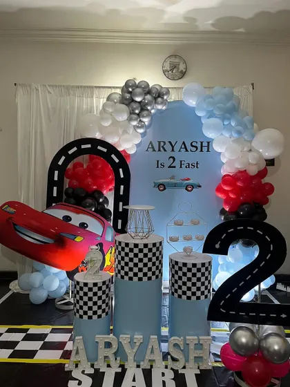 Another take on the "2 Fast" car racing theme. This version includes a large Lightning McQueen cutout, checkered pedestals, and a custom backdrop.