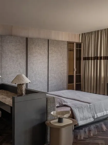 The master suite in the Aikaa show villa, designed to feel refined yet relatable. We used a palette of grays and dark wood, with custom furniture like the integrated desk behind the bed.