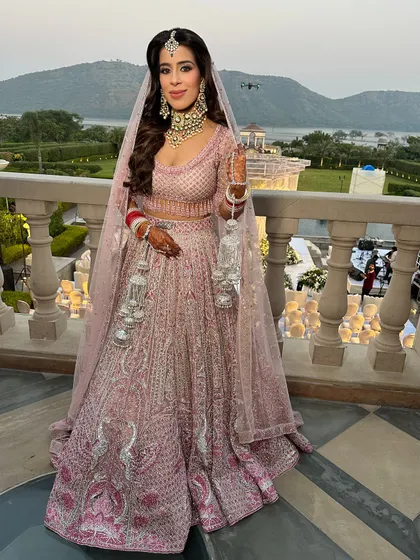 A breathtaking view with a breathtaking bride. For her wedding at a palace hotel, we created a soft glam look with gentle waves in her hair to complement her Falguni Shane Peacock lehenga.