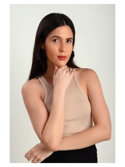 A simple and classic studio portrait. The neutral-colored top and clean background keep the focus on the model's natural beauty.