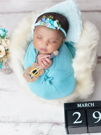 A tiny musician dreaming sweet melodies. Using miniature props like this guitar adds a unique and personal touch to your newborn's portraits.