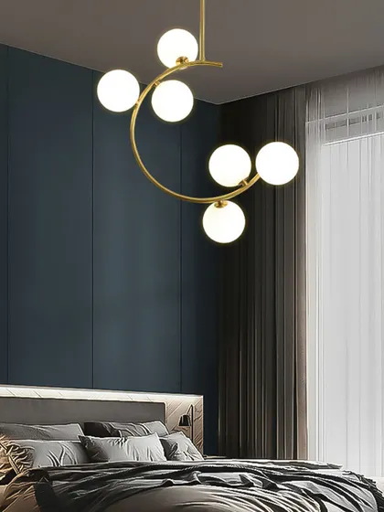 The crescent-shaped chandelier shown in a bedroom setting. Its gentle curve and soft light create a relaxing and sophisticated atmosphere.