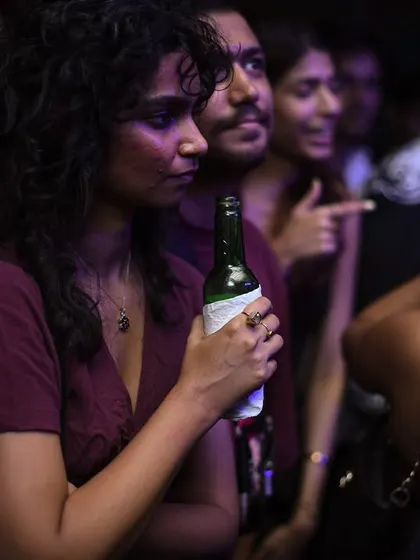 Someone enjoying a drink and taking in the atmosphere. It's a place to chill or to go hard.
