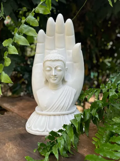 Our white marble Buddha in a blessing hand, nestled among garden ferns, radiates an aura of pure peace and serenity.