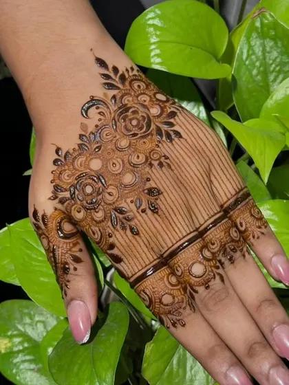 A modern take on party mehndi, with a floral bunch and delicate lines covering half of the hand. This style is very trendy and looks great in photos.