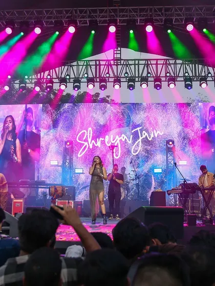 A wide angle of Shreya Jain's performance, showing the full stage production, lighting design, and the massive crowd. This shot gives a sense of the epic scale of the music festivals I cover.