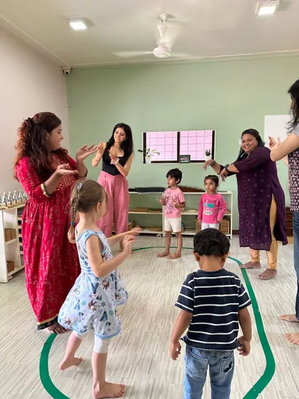 Our teachers lead a group of children in a movement activity. We use dance and gestures to help embody musical concepts like rhythm and tempo.