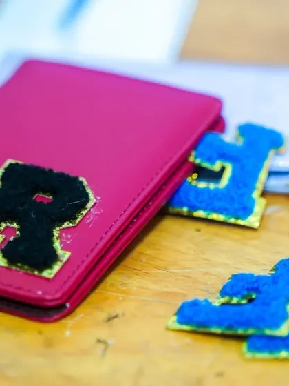 A personalized craft station where guests can decorate items like passport holders with their initials.