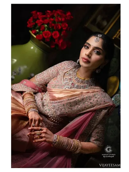Ashitha Reddy looking regal for her reception. The makeup features a soft pink eyeshadow and a defined liner, which beautifully complements her ornate rose gold and pink saree.