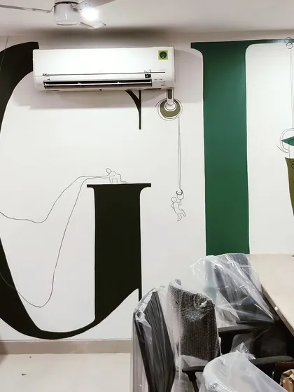 A view of the 'GROWTH' typography mural in an office space. The large letters are intertwined with line art depicting people working together, symbolizing progress and teamwork.
