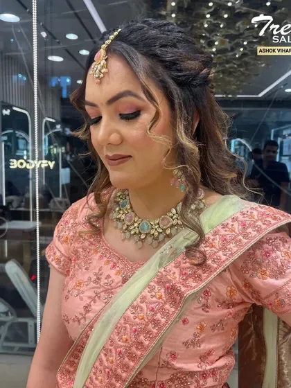 A soft and romantic look for a daytime event. The makeup features a subtle pink eyeshadow and glowing skin, paired with a half-up hairstyle that is both elegant and modern.