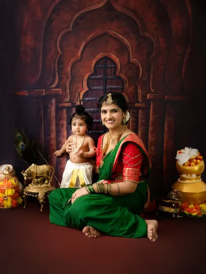 A full-length view of the mother and child in their beautiful traditional attire for the Krishna Janmashtami session.
