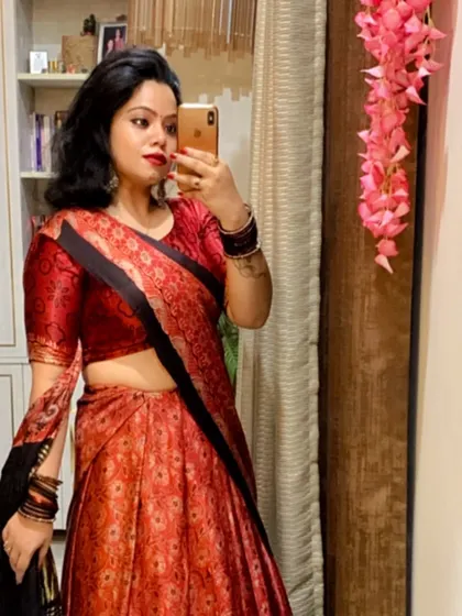 A mirror selfie showing a red and black lehenga, perfect for checking your look before heading to a Navratri event.