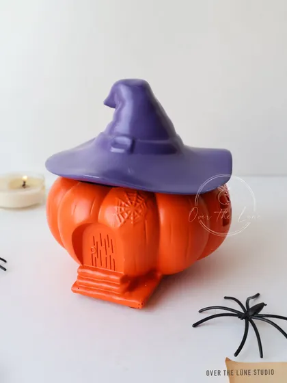 My 'Witch House Pumpkin Jar' is a decorative trinket box perfect for Halloween. The pumpkin base has a little house carved into it, and the lid is a witch's hat.