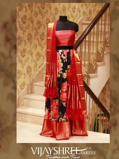 A modern Kanjivaram half saree with a black floral skirt and a bright red blouse and dupatta, perfect for a sangeet or reception.