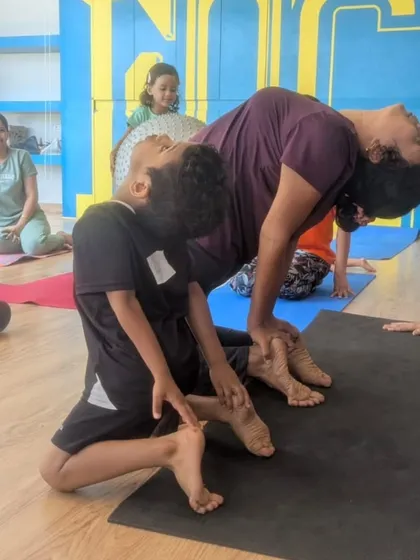 Here I am assisting a student with his camel pose to ensure he achieves a deep, safe stretch. Proper guidance is key to helping kids improve their flexibility without straining.