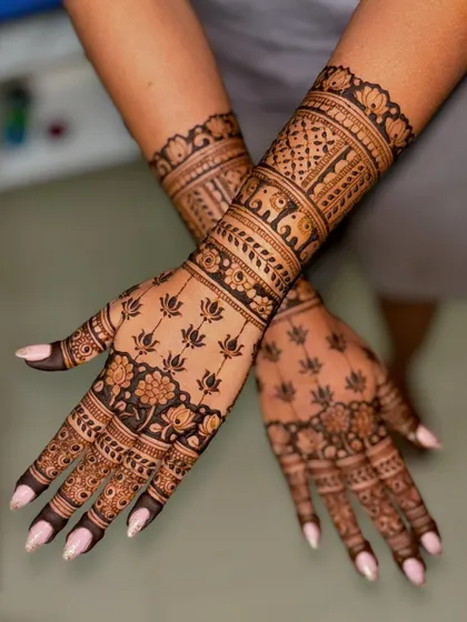 An engagement design rich with traditional motifs, including lotus flowers on the palm and elephants on the wristband.