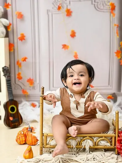 A huge, happy grin from this adorable sitter. At this age, babies are full of expression, and this teddy bear-themed shoot was the perfect way to capture his joyful personality.