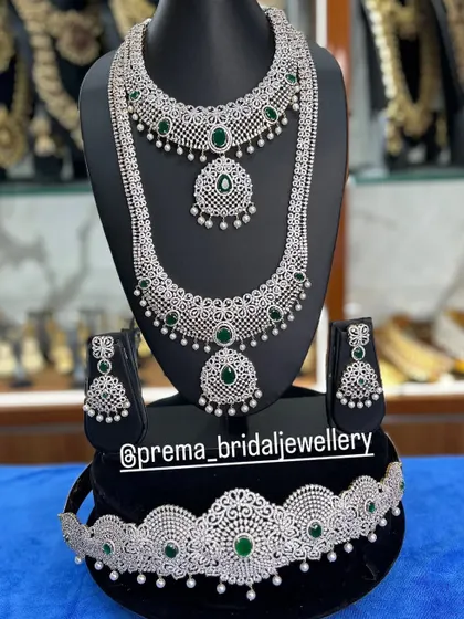 A complete AD and emerald bridal set with a matching choker, haaram, and vaddanam.