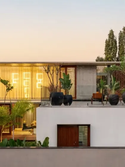 An evening view of the Long House, where the composition of stacked, horizontal volumes is illuminated, highlighting its clean lines and minimalist clarity.