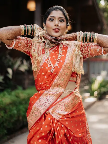 A playful portrait of the bride showing off her traditional 'kalire' jewelry.