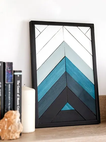 A small, framed geometric art piece with a blue chevron pattern. It's perfect for shelf decor, office desks, or as part of a larger gallery arrangement.