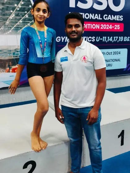 A proud coach stands with one of our top performers on the podium. This represents the culmination of teamwork and personalized training.