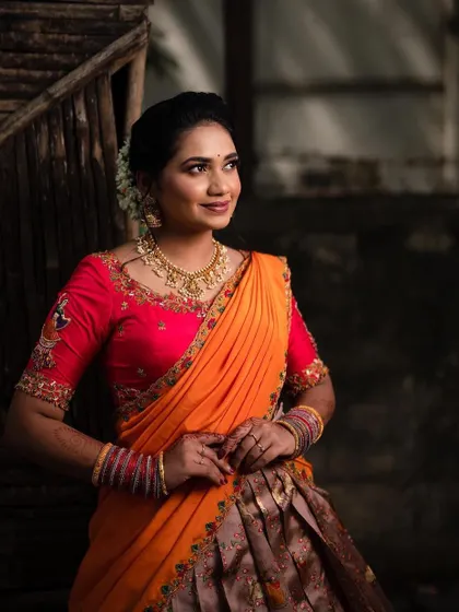 A beautiful three-quarter shot of the model, showcasing the intricate blouse embroidery and the drape of the orange dupatta.