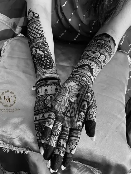 A black and white shot that highlights the clean lines and contrast of a portrait design. It features a varmala ceremony scene, showcasing the timeless beauty of henna art.