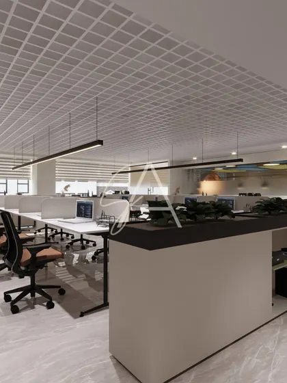 An overview of the main workstation floor, designed for efficiency and flow. A central planter box divides the space and adds a touch of green, while the grid ceiling helps with acoustics and conceals services for a clean look.