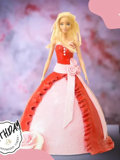 A stunning Barbie doll cake in a beautiful red and pink gown. The intricate details on the dress and the elegant pose make this a truly show-stopping centerpiece.