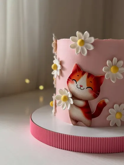 A close-up of the happy cat and daisy cake, showing the clean finish and sweet character details.