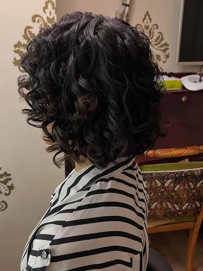 A different angle showcasing the texture and movement in this short curly haircut.