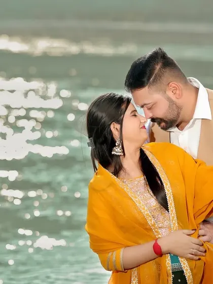 An intimate and happy moment between a couple by the glistening water of the Ganga. The natural light and their joyful expressions make this a beautiful, candid shot.