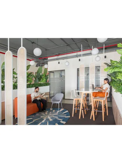 This wide shot shows how the different elements of the breakout area come together. The high table is ideal for quick stand-up meetings, while the softer seating invites longer conversations.