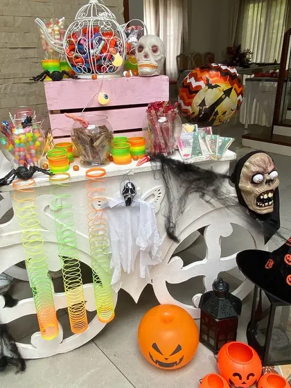 Another view of the Halloween candy cart, overflowing with spooky treats and decorations. This is a great way to create a central hub for fun and sweets at a kids' party.