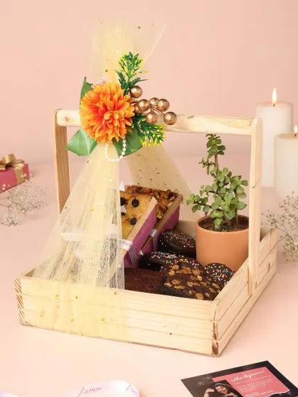 A beautifully arranged Diwali hamper in a wooden basket, featuring my baked goods and a small plant for a lasting gift.
