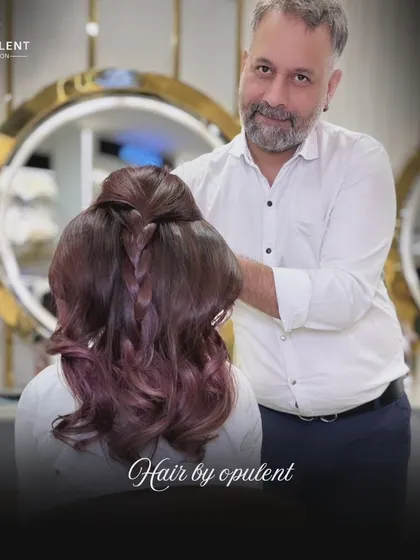 A closer look at the styling for this beautiful reddish-purple hair. A simple braid detail adds a touch of elegance and shows off the multi-dimensional tones.