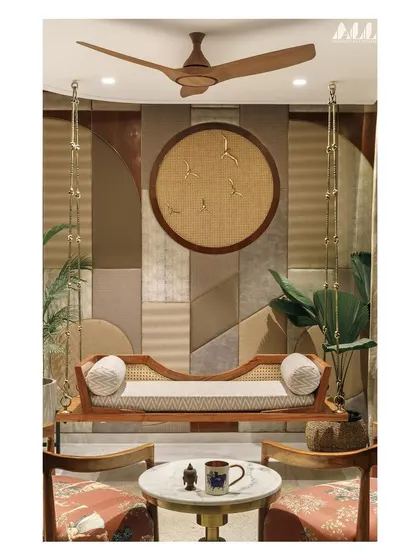 A full view of the informal living space, showcasing the contemporary swing, textured wall panel, and accent chairs. The design creates a cozy yet sophisticated corner for conversation and relaxation.